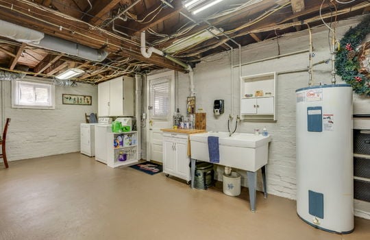 basement, washer/dryer hookup, water heater, concrete flooring, exterior door, utility sink