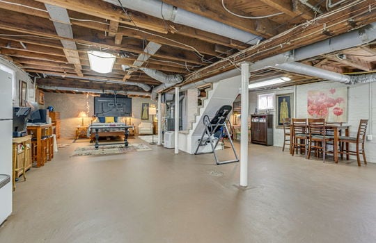 basement, concrete flooring, heated/cooled, carpeted stairs, painted brick wall,