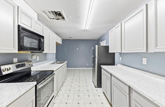 kitchen, cabinets, countertops, vinyl flooring, built in microwave, oven/range, sink, refrigerator