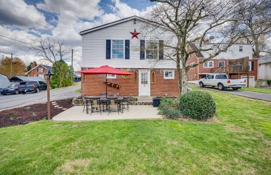 back of home, vinyl siding, brick, exterior door, rear patio, concrete pad, back yard, side yard, landscaping