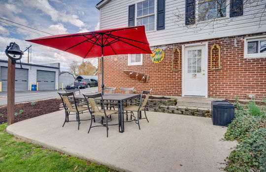 rear patio, concrete pad, exterior door, brick, vinyl siding, landscaping