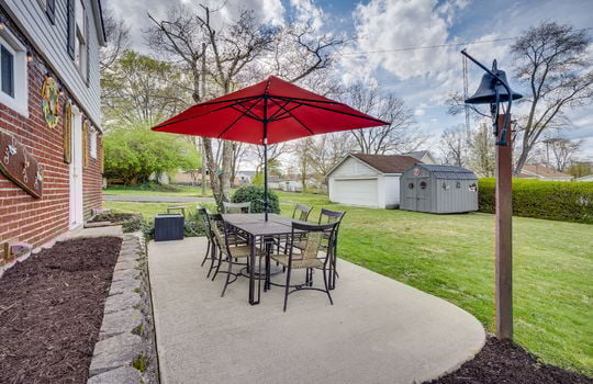 rear patio, concrete pad, exterior door, brick, vinyl siding, landscaping, back yard, storage shed