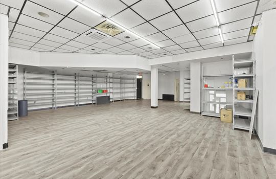 commercial property for lease, shelving, ceiling tiles, fluorescent lighting, bathroom entrance door