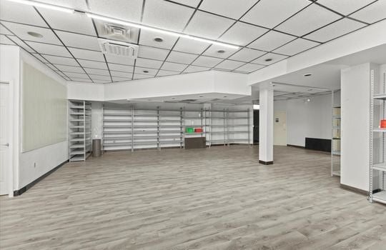 commercial property for lease, shelving, ceiling tiles, fluorescent lighting, bathroom entrance door