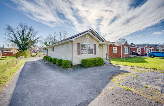 office space, front of office, concrete porch, steps to porch, vinyl siding, parking spaces, driveway, landscaping
