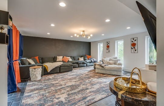 living room, tile flooring, recessed lighting, large windows,