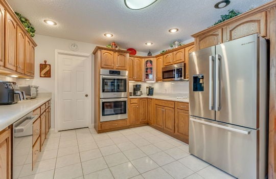 kitchen, dishwasher, double wall oven, countertop cooktop, built in microwave, refrigerator, cabinets, countertops, tile flooring, recessed lighting