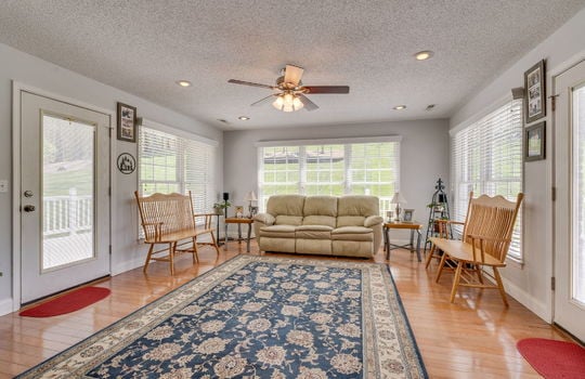 living room, exterior doors to back deck, ceiling fan, recessed lighting, hardwood flooring, windows