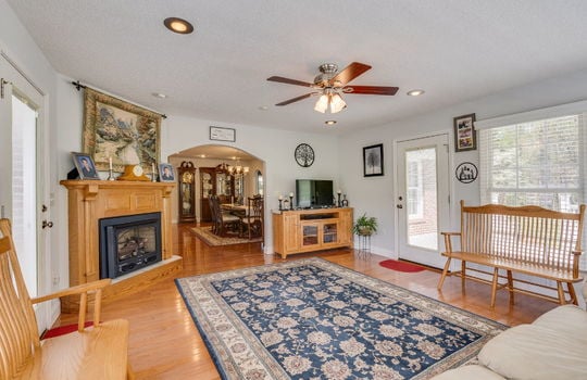 living room, hardwood flooring, doors to back deck, windows, fireplace, ceiling fan, recessed lighting