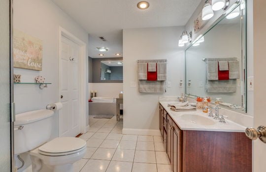 ensuite bathroom, tile flooring, toilet, double vanity sink, tub, closet