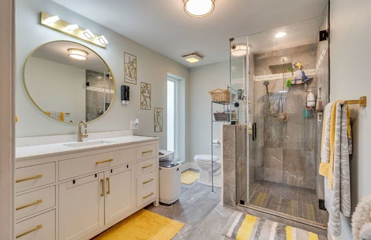 bathroom, tile flooring, tile shower, glass shower door, sink, toilet,