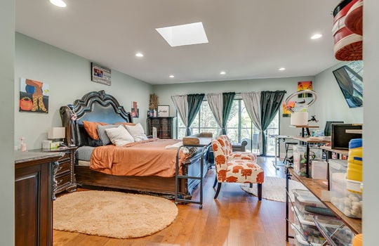 large bedroom, skylight, recessed lighting, hardwood flooring, glass doors to balcony