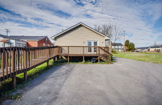 ramp, handicap accessible access, wood railings, wood deck, back door, vinyl siding, parking lot, wood stairs