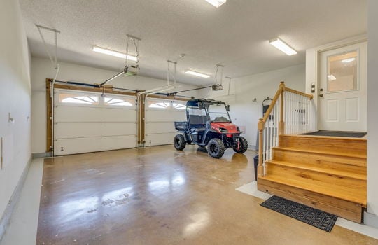 attached garage, concrete flooring, garage doors, interior entry toodr, stairs