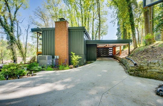back side of home, contemporary home, chimney, driveway, retaining wall