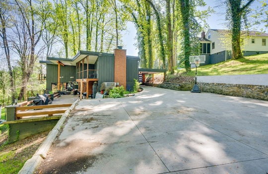 back side view of home, driveway, parking pad, back balcony, back deck, back patio, glass entry doors, contemporary home