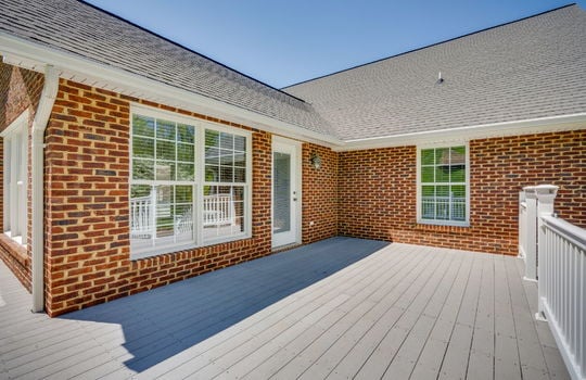 deck, exterior entry door, brick home exterior, roof, railing, steps