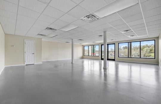 Open floor plan, ceiling tiles, glass windows, glass doors, fluorescent lighting