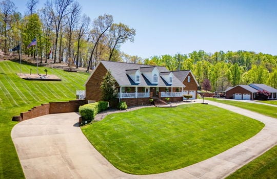 two story brick home,driveway, covered front porch, brick exterior, front yard, two car garage, driveway, back yard, trees, neighboring home