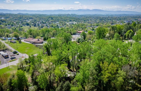 aerial view of home, trees, neighboring properties, mountains