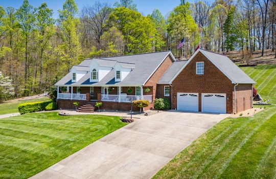 two story brick home, two car garage, driveway, front yard, front porch, covered front porch, brick exterior, front yard, trees