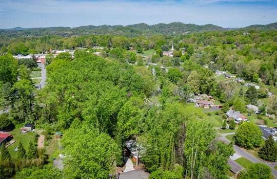 aerial view of home, trees, neighboring properties, mountains