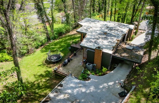 aerial view over parking area, patio, driveway, back yard