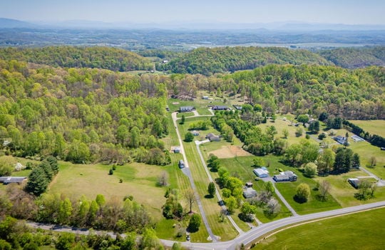 aerial view of property, driveway, private drive, front yard, back yard, neighboring homes, trees, mountains, road