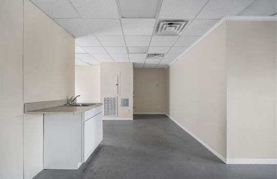 Utility area, commercial space for lease, sink area, cabinet, concrete flooring, ceiling tiles, fluorescent lighting