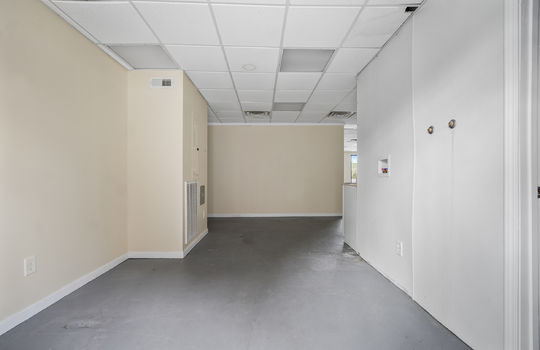 Back entrance, washer/dryer hookups, concrete flooring, ceiling tiles, fluorescent lighting