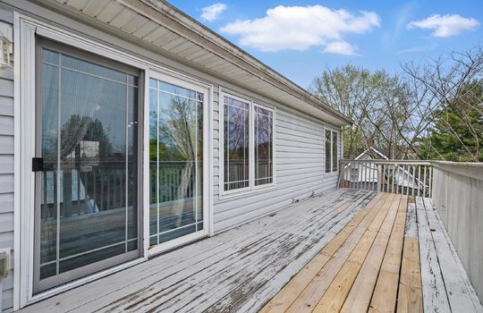 back balcony, wood balcony, vinyl siding, doors to interior, screen door