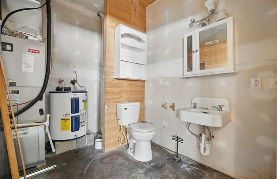 half bath, concrete flooring, water heater, hvac unit, sink
