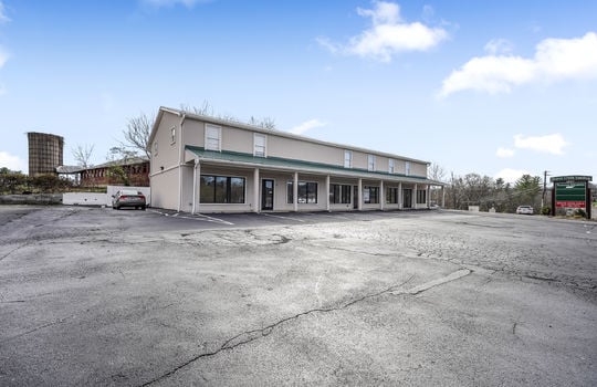 Commercial property for lease, sign, parking lot, display windows, doors, metal roof, covered entrance, parking lot