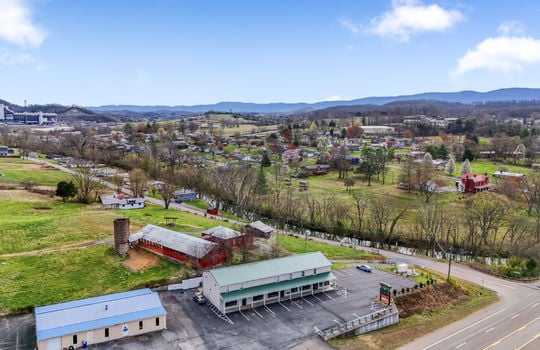 aerial view of property, parking lot, commercial building, commercial space for lease, parking lot, road, nearby homes, farms, fields, mountain views, Bristol Motor Speedway