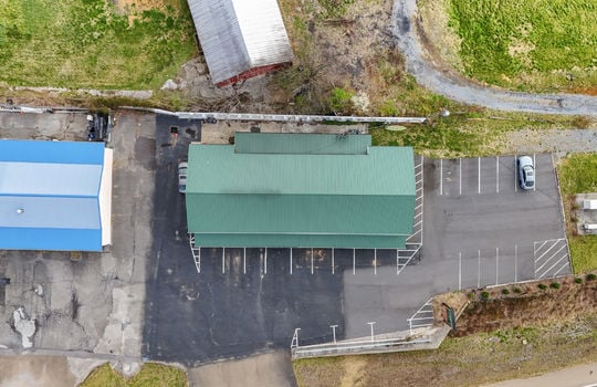 aerial view of property, roof, metal roof, parking lot