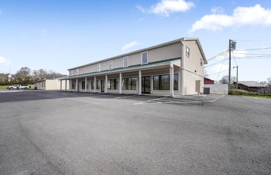 commercial space for lease, display windows, doors, covered entrance, metal roof, parking lot