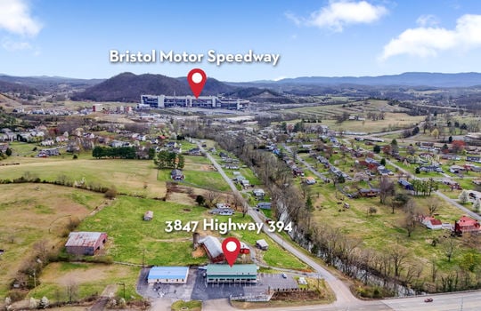 commercial building, commercial space for lease, parking lot, metal roof, property marker, property marker for Bristol Motor Speedway, neighboring properties, mountain views