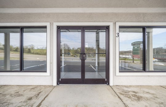 covered front entrance, glass double doors, glass display windows