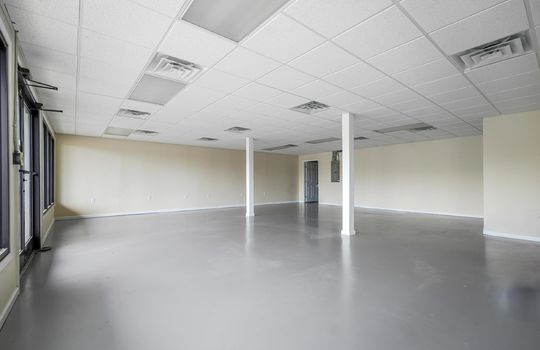 commercial property, large open space, concrete flooring, pillars, ceiling tiles, fluorescent lighting, door, windows