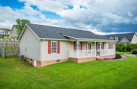 left side view of home, front yard, ranch style home, covered front porch, front door, fencing for back yard