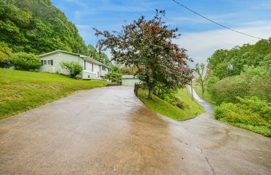 driveway, landscaping, yard, shed/workshop, split level home, brick & wood siding exterior, trees, road