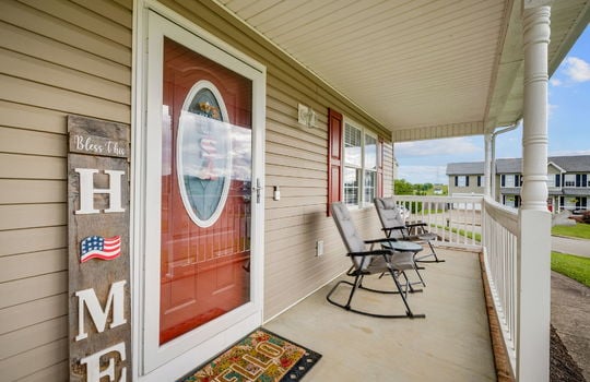front porch, concrete flooring, covered front porch, storm door, front door, window, vinyl siding