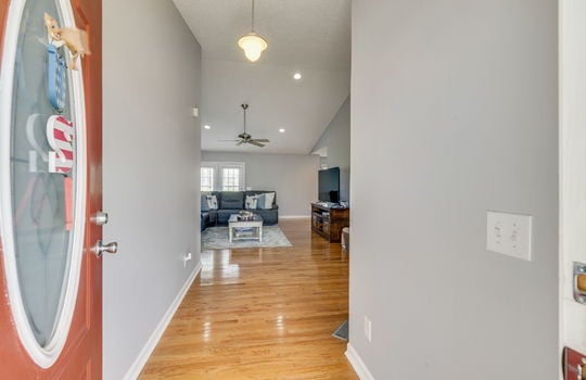 front door, entry way, hardwood flooring, recessed lighting, view into living room