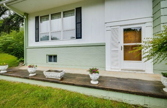 front porch, front door, brick, wood siding, window, front yard, trees