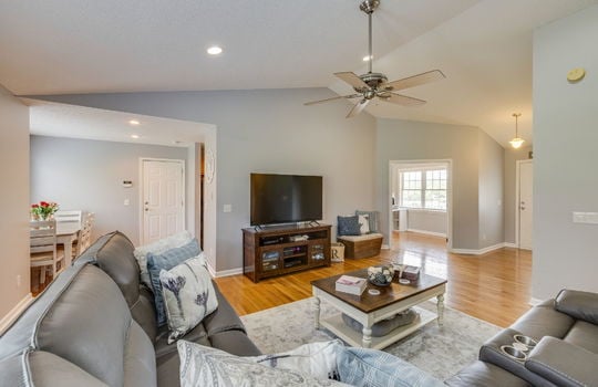 living room, vaulted ceiling, ceiling fan, hardwood flooring, view into dining space