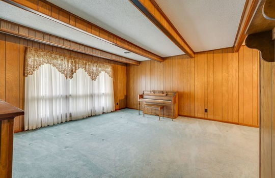 living room, carpet, ceiling beams, large windows, paneling walls