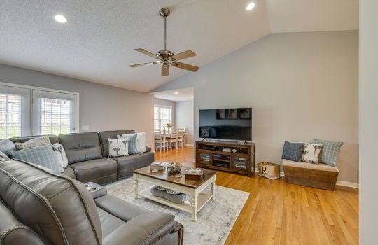 living room, vaulted ceiling, recessed lighting, ceiling fan, hardwood flooring, view into dining space