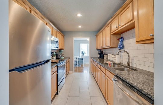 kitchen, countertops, cabinets, refrigerator, stove, built-in microwave, sink, dishwasher, tile backsplash, tile flooring, recessed lighting