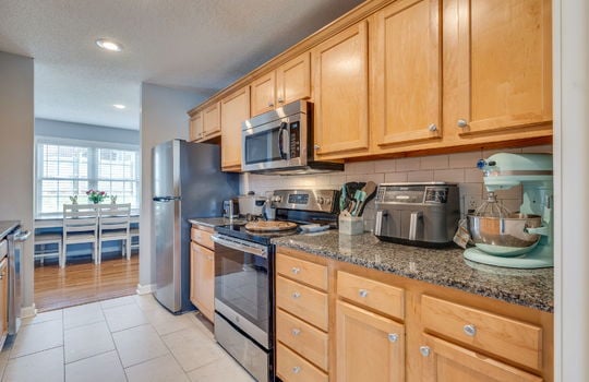 kitchen, cabinets, tile backsplash, countertops, refrigerator, stove, built-in microwave