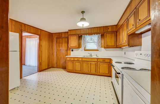 kitchen, vinyl flooring, wood cabinets, paneling walls, refrigerator, dishwasher, oven/range, wood cabinets, countertops, sink, window above sink, exterior door